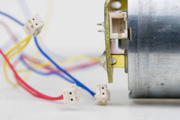 istock Small electric motor on a white workshop table. Electric drive used in small electrical devices. Light background. 981943594
