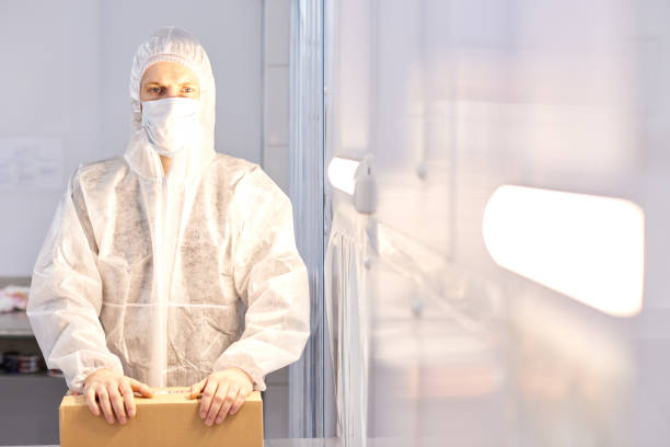 istock Factory worker with box standing in protective clothing 981943786