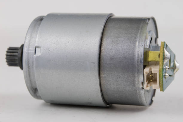 istock Small electric motor on a white workshop table. Electric drive used in small electrical devices. Light background. 981947972