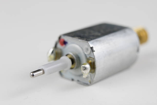 istock Small electric motor on a white workshop table. Electric drive used in small electrical devices. Light background. 981948290