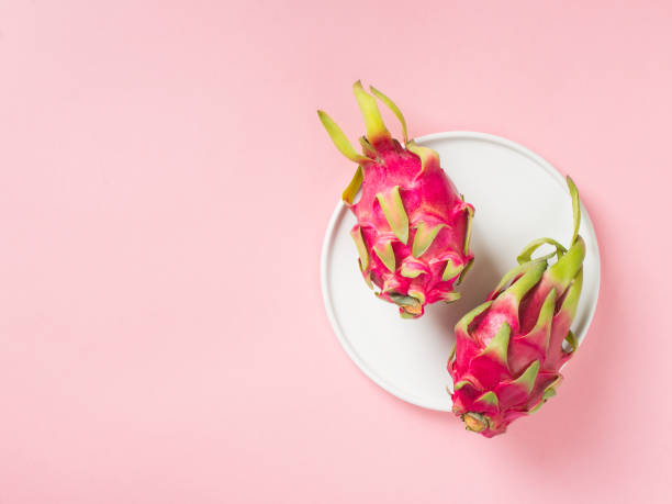 Pitaya or dragonfruit in a plate on pink background