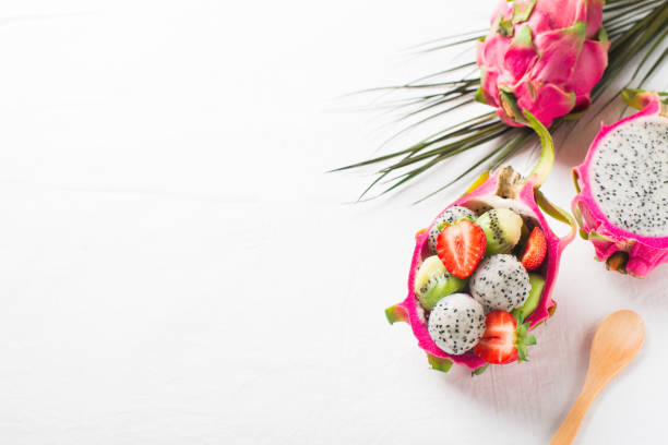Exotic fruit salad with pitaya, strawberry and kiwi on white background