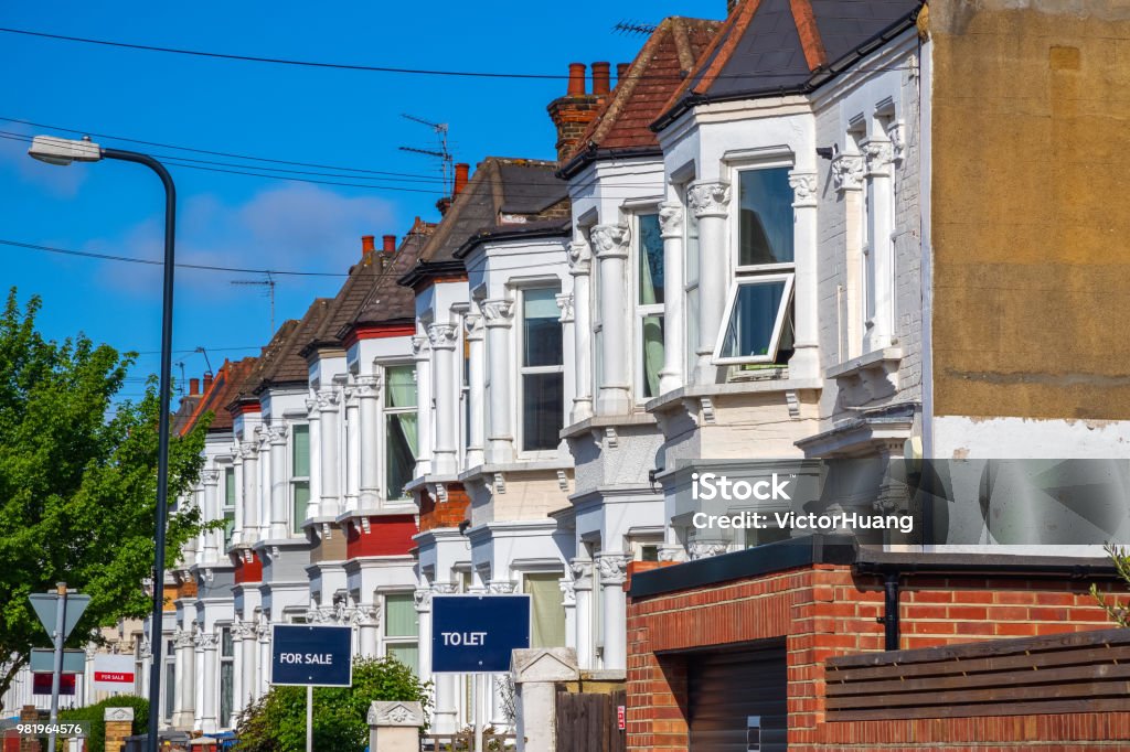 British terraced houses in London with estate agent boards A row of typical British terraced houses around Kensal Rise in London with estate agent boards UK Stock Photo