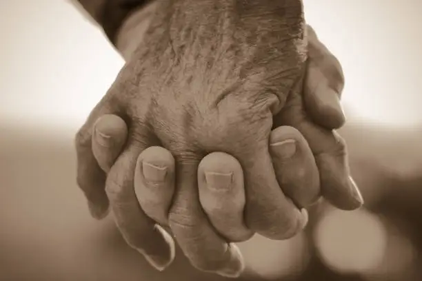 elderly couple holding handss