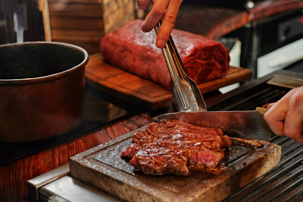 istock A man cooking beef steak on a grill. 981973930