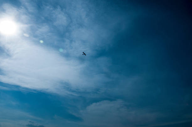 istock Airplane in a blue sky with the sun 981986474