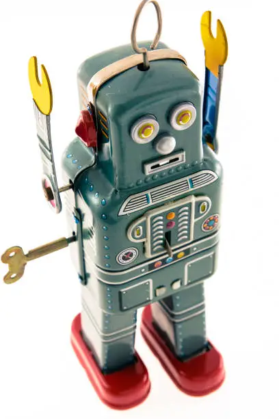 retro robot with hands up to surrender, on white