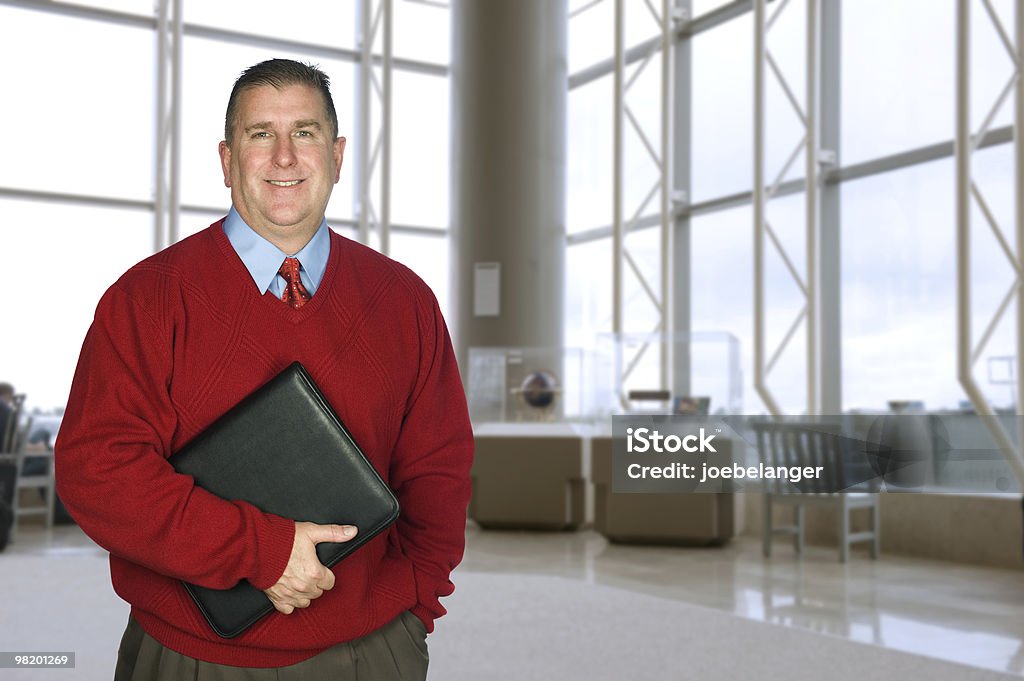Businessman with leather folder in lobby  45-49 Years Stock Photo