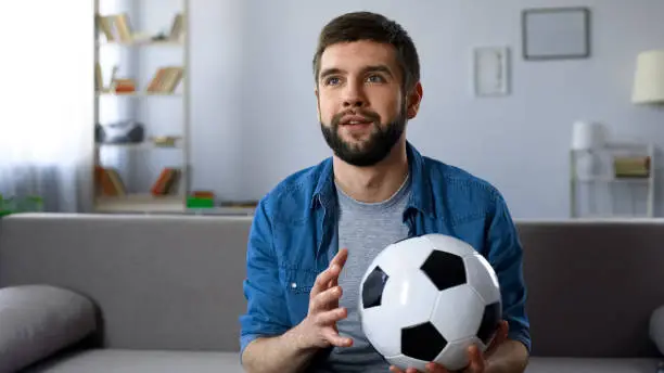 Photo of Football supporter attentively watching game on TV, hope of victory championship