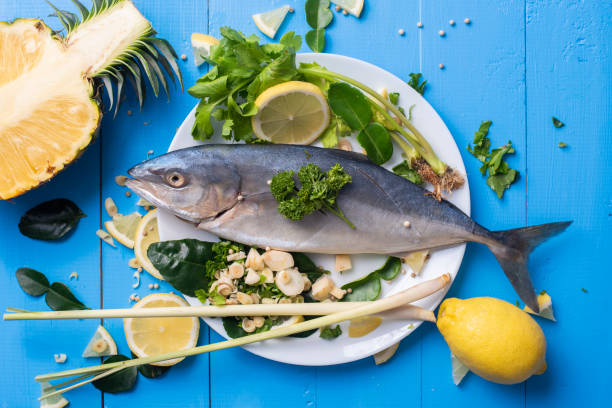 istock Fish food with ingredient spices on blue table 982021368