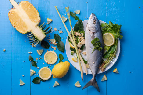istock Fish food with ingredient spices on blue table 982021386