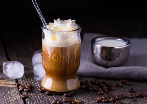 istock Ice coffee in a small glass on dark natural desk. 982025600