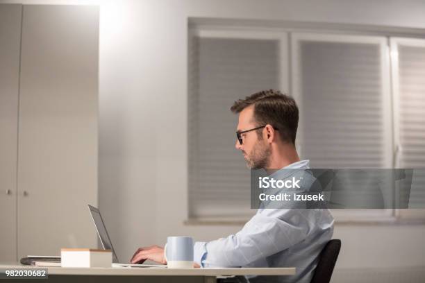 Mature Man Working On Laptop In Office Stock Photo - Download Image Now - Adult, Adults Only, Business