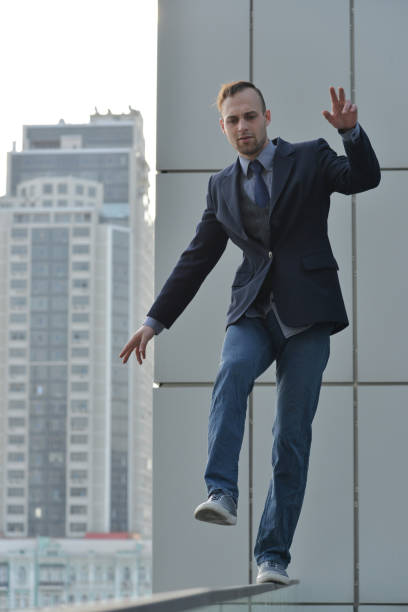 istock brave businessman walking on a skyscraper roof 982046050