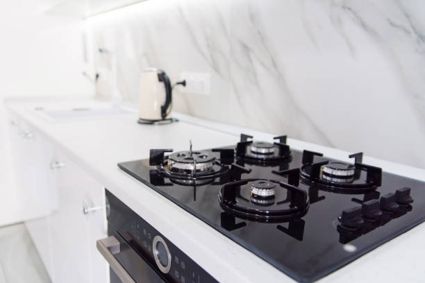 estufa de gas negro moderno de alta tecnología con el panel del sensor en el luminoso interior de la cocina - gas ranges fotografías e imágenes de stock