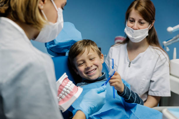 istock Doctor dentist teaching a child to brush teeth. 982047372