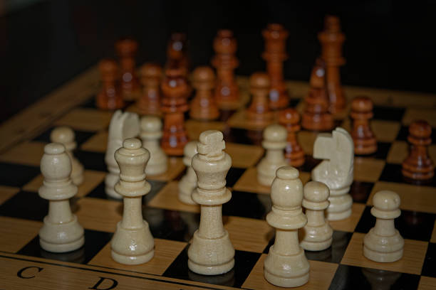 istock Wooden material chess board and chess pieces in low light 982104938