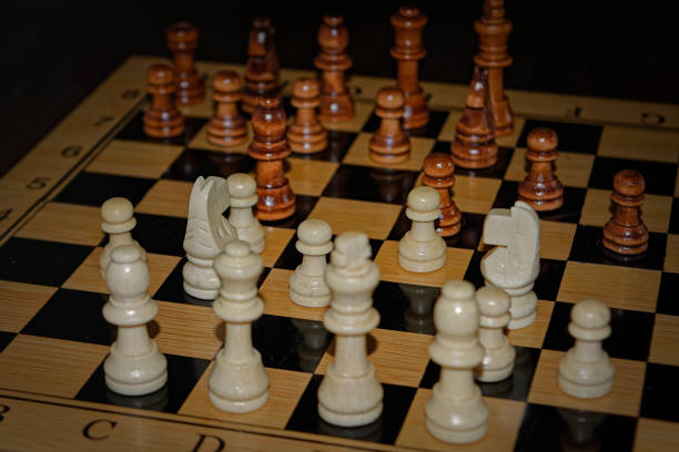 istock Wooden material chess board and chess pieces in low light 982105012