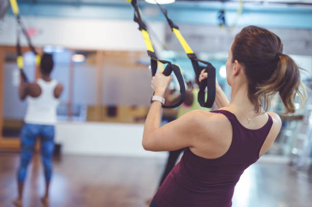 istock Middle-aged woman does a suspension workout in a modern gym 982108058