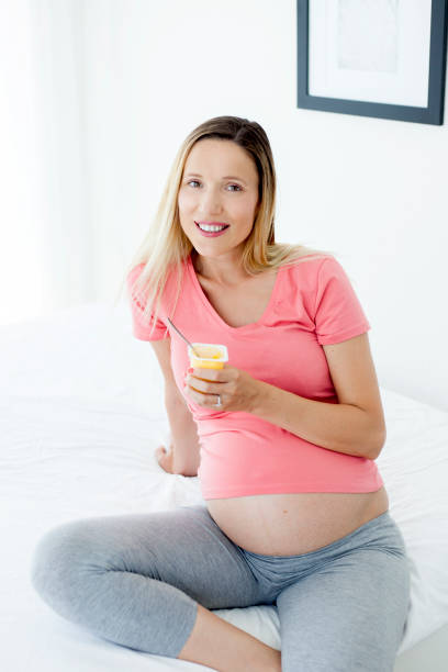 istock Pregnant woman eating yogurt 982112294