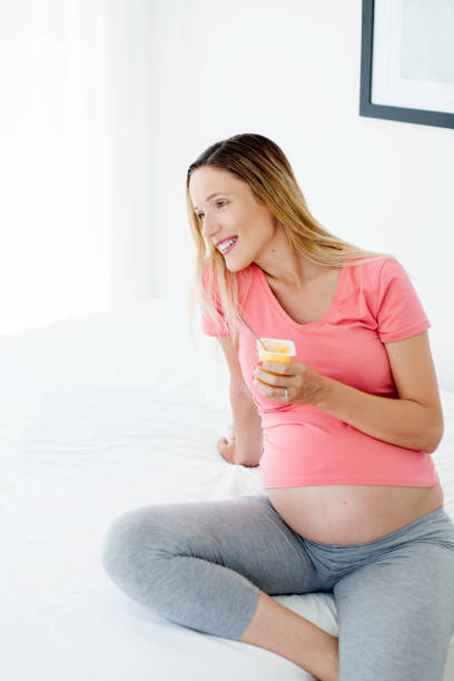 istock Pregnant woman eating yogurt 982116856