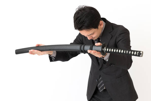 portrait of asian businessman using samurai sword isolated on white background