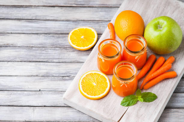 istock Jars with carrot juice, apple, sliced orange and mint leaf 982136968
