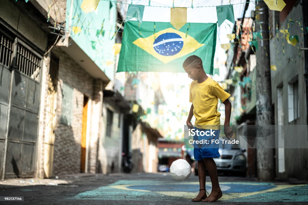 Brazilian Kid Playing Soccer in the Street Soccer is a world passion Soccer Stock Photo