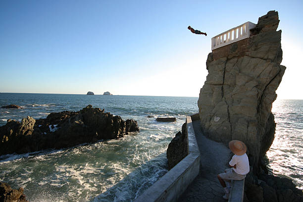 Acapulco, Mexico- March 3, 2011: Cliff diver at La Quebrada in Acapulco Mexico. Divers wave at the crowds before their afternoon performance. Divers perform both day and night for tourists risking their lives. Dives must be timed for when the water level is high enough.
