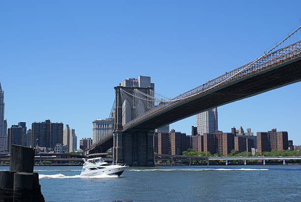 Barca sotto Ponte di Brooklyn - foto stock