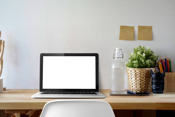 istock Contemporary workspace with mockup blank screen laptop on wooden desk. 982151594