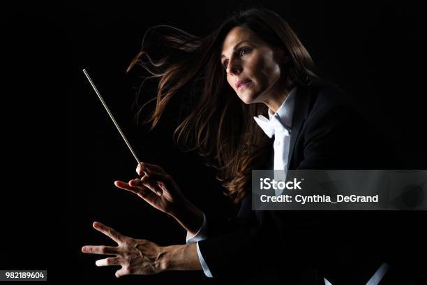 Woman In Tuxedo Conducting With Baton Stock Photo - Download Image Now - Musical Conductor, Black Background, Women