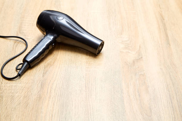 istock black hair dryer on wood background. 982257758