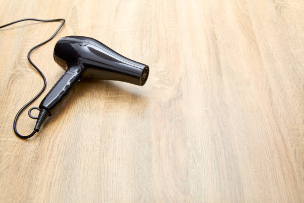 istock black hair dryer on wood background. 982257794