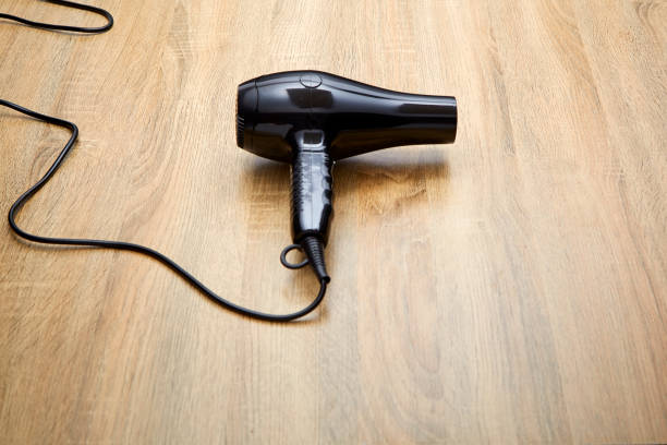istock black hair dryer on wood background. 982257796
