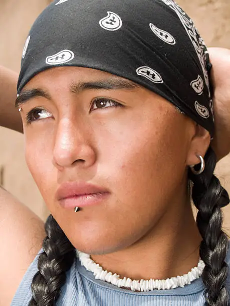 Photo of Close-up headshot of Native American teenage boy with braids