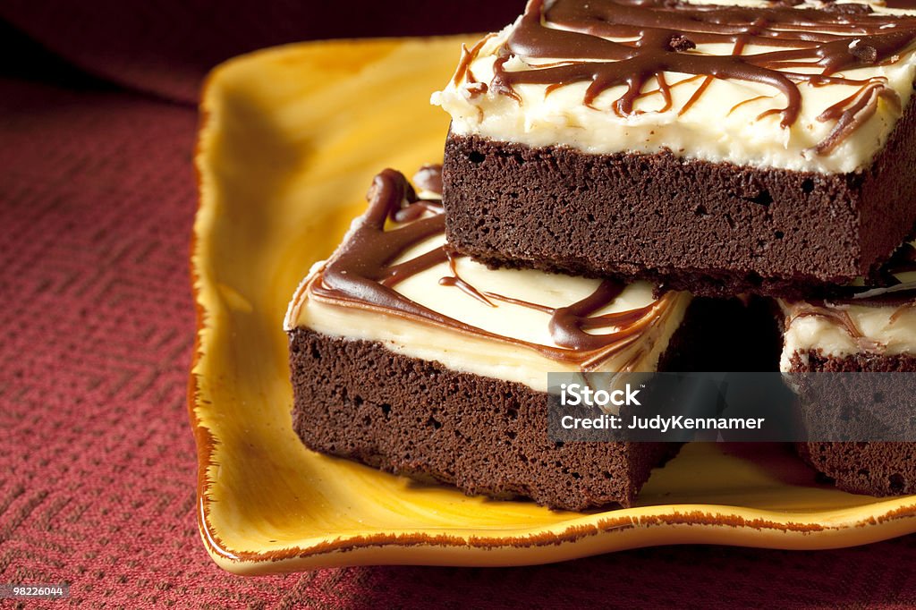 Frosted brownies on yellow plate  Baked Stock Photo