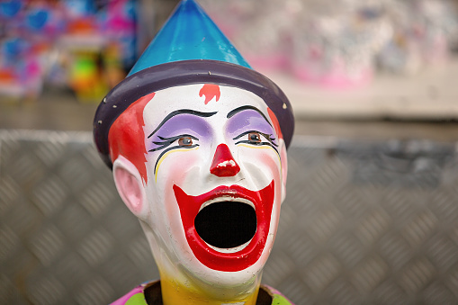 A painted clown figurine with open mouth ready for child to put in a bull and gain points at a country show