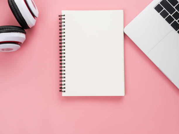 leere notebook, kopfhörer und laptop auf rosa hintergrund. - notebook book paper note pad stock-fotos und bilder