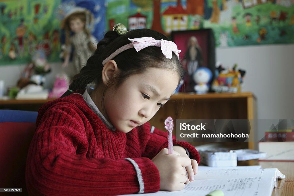 Niña en edad escolar estudiando en su casa - Foto de stock de 6-7 años libre de derechos