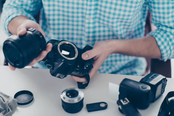 cropped close up non face portrait of man assemble camera after repair expertising, having lens flash small details on the table - office tool flash imagens e fotografias de stock