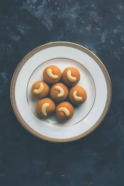 Photo of Rava Ladoo or Semolina Laddu with cashew nut topping, popular festival food from India. served in a plate selective focus