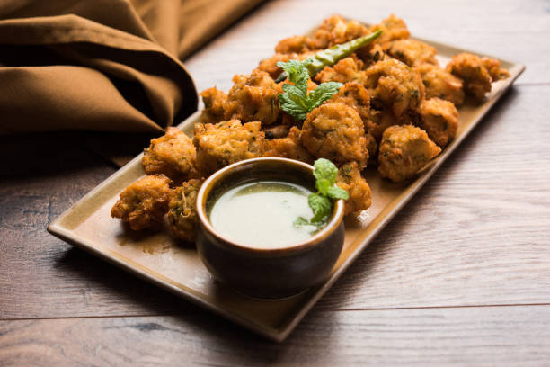 istock Moong Dal Vada or Pakoda also known as Moongode Served with Green Chutney. selective focus 982313812