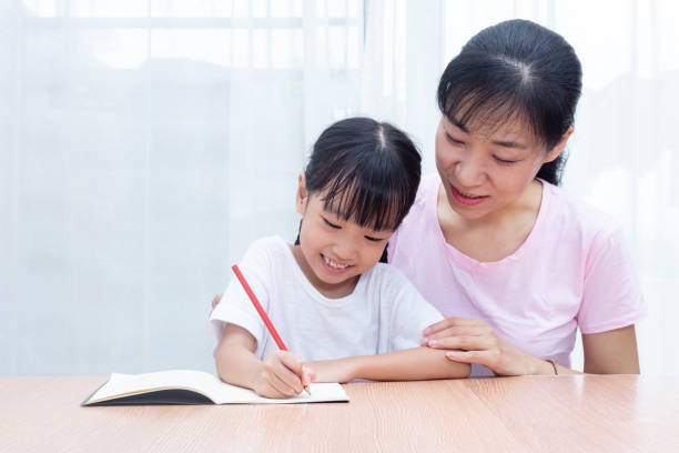 istock Asian Chinese mother teaching daughter doing homework 982332150