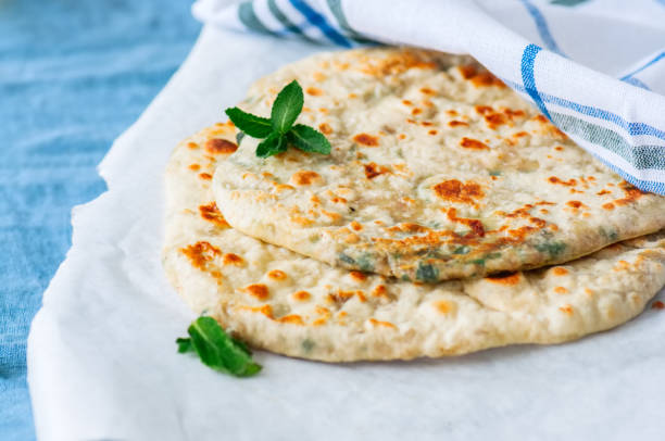 istock Indian flatbread - Herb stuffed paratha on a baking paper 982336292
