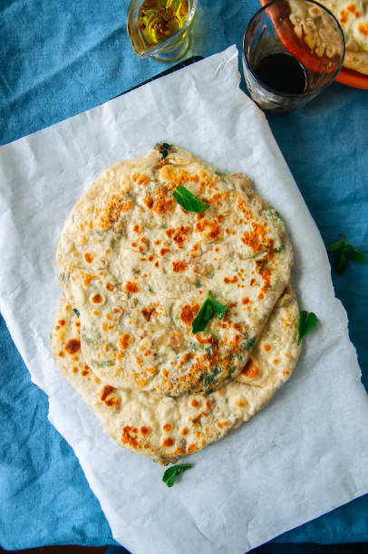 istock Indian flatbread - Herb stuffed paratha on a baking paper 982336294