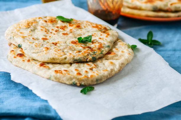 istock Indian flatbread - Herb stuffed paratha on a baking paper 982336304