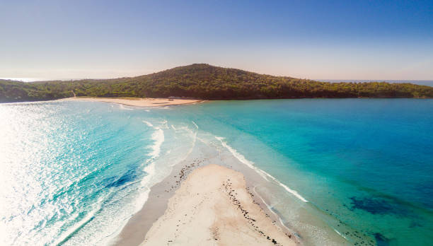 istock Fingal sand spit as high tide washes in cutting access 982349504