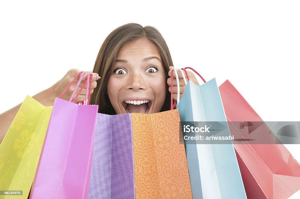 Shopping Shopping woman. Happy excited woman holding her shopping bags while screaming of joy. Beautiful cute mixed race caucasian / chinese young woman model. Isolated on white background. Click to see more of our similar pictures:http://i.istockimg.com/file_thumbview_approve/16652394/1/16652394-shopping-woman-happy.jpg Shopping Stock Photo