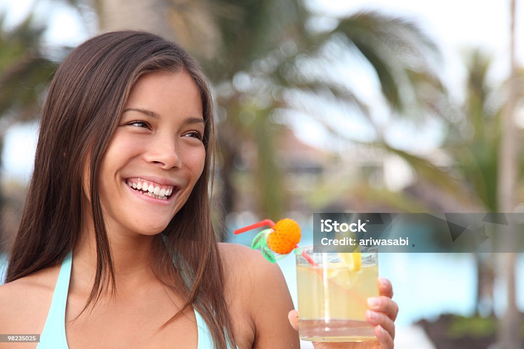 Mujer teniendo una bebida en un ambiente de complejo turístico tropical - Foto de stock de Beber libre de derechos